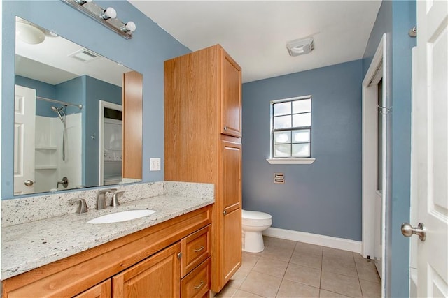 bathroom with vanity, a shower, toilet, and tile patterned flooring