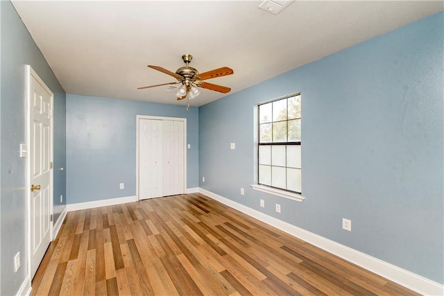 unfurnished bedroom featuring a closet, ceiling fan, and wood-type flooring