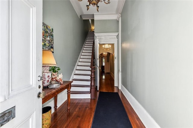 interior space featuring ornamental molding, dark hardwood / wood-style floors, and a chandelier