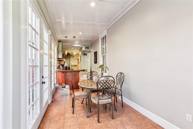 tiled dining area featuring french doors and crown molding