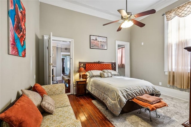 bedroom with ornamental molding, multiple windows, dark hardwood / wood-style floors, and ceiling fan