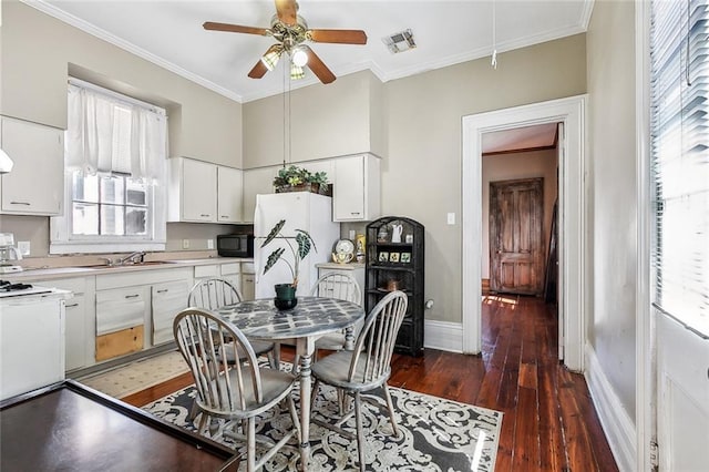 kitchen with ornamental molding, dark hardwood / wood-style floors, white cabinets, and plenty of natural light