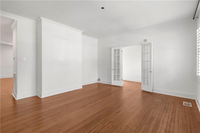 spare room with french doors, hardwood / wood-style flooring, and ornamental molding