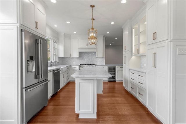 kitchen with white cabinetry, stainless steel appliances, a center island, and wine cooler