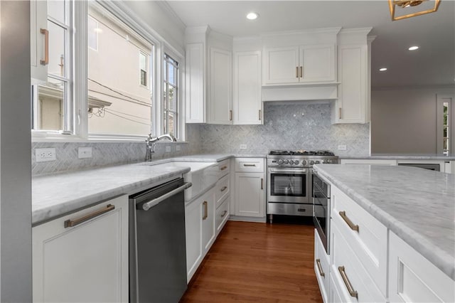 kitchen with dark hardwood / wood-style flooring, white cabinetry, light stone counters, and stainless steel appliances