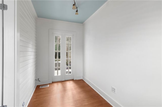 entryway with light hardwood / wood-style flooring and crown molding