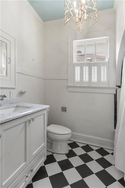 bathroom with toilet, vanity, a notable chandelier, and ornamental molding