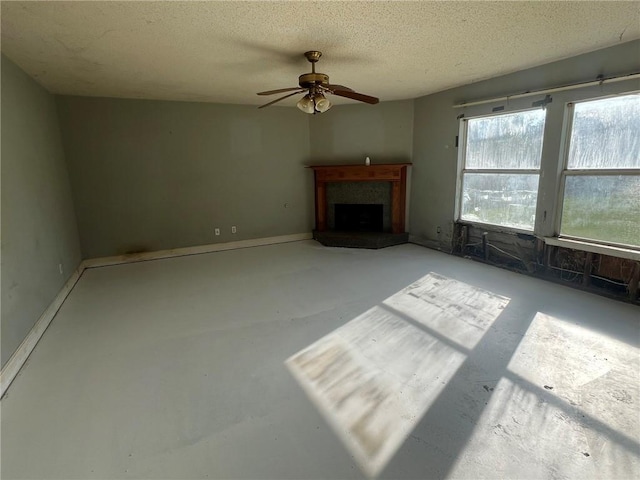 unfurnished living room featuring a textured ceiling and ceiling fan