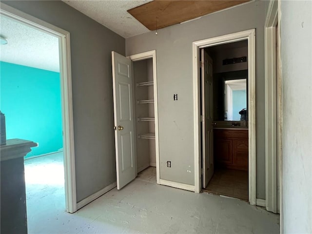 unfurnished bedroom featuring a walk in closet and connected bathroom