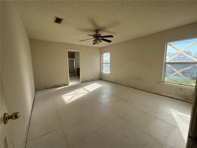 empty room featuring ceiling fan and a textured ceiling