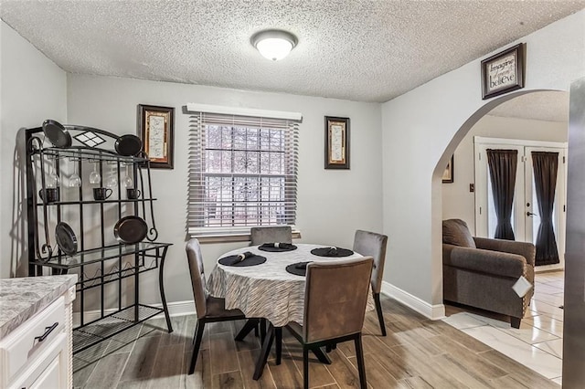 dining area featuring light hardwood / wood-style floors and a textured ceiling