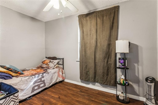 bedroom featuring dark hardwood / wood-style floors, a textured ceiling, and ceiling fan