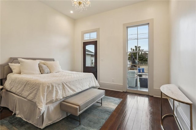 bedroom with access to exterior, dark hardwood / wood-style floors, and an inviting chandelier