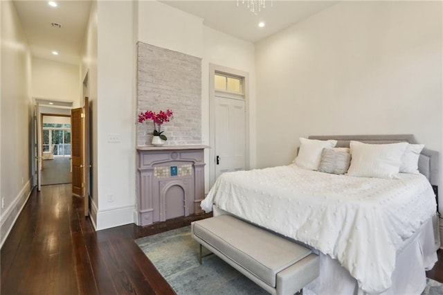 bedroom with dark hardwood / wood-style floors and an inviting chandelier