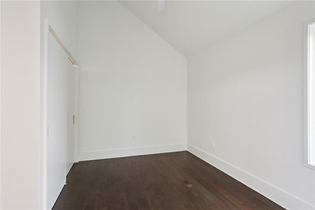 interior space featuring dark wood-type flooring and lofted ceiling