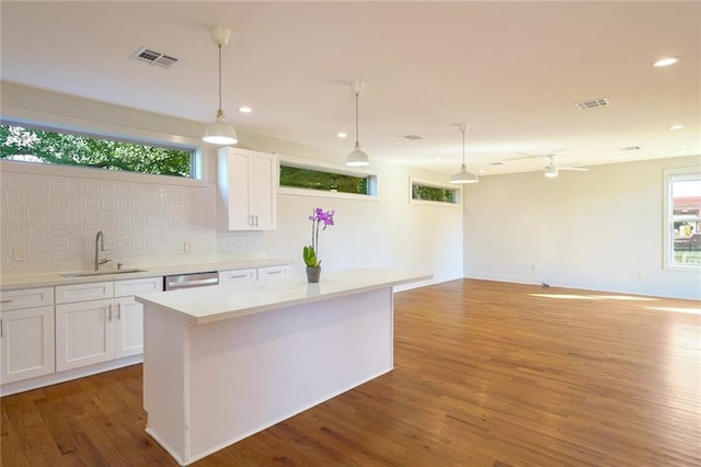 kitchen with white cabinetry, decorative light fixtures, and sink