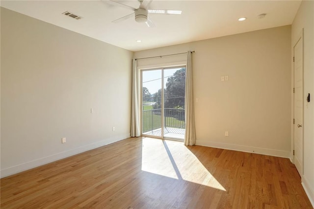 empty room with ceiling fan and light hardwood / wood-style flooring