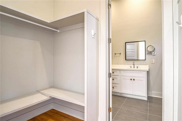 walk in closet featuring sink and dark tile patterned floors