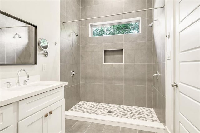 bathroom featuring tiled shower and vanity