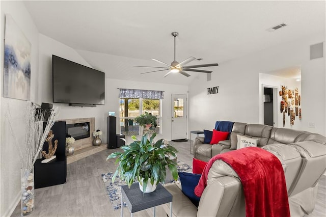 living room featuring lofted ceiling, light hardwood / wood-style floors, and ceiling fan