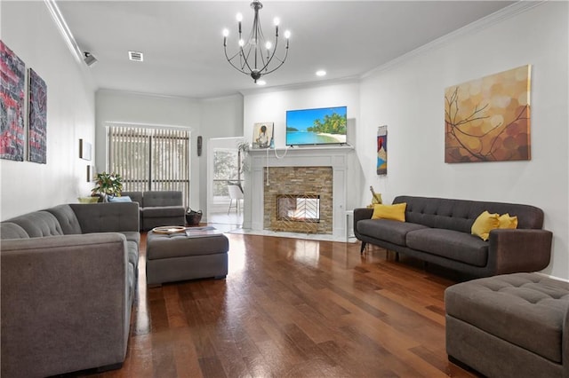 living room with crown molding, a notable chandelier, a stone fireplace, and hardwood / wood-style flooring