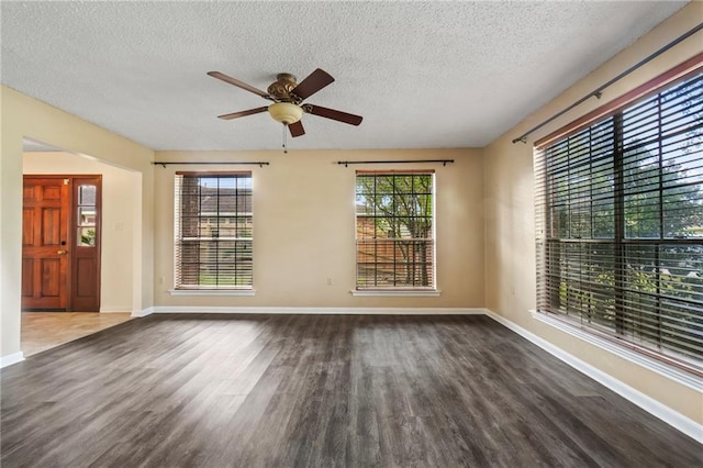 empty room featuring a textured ceiling, ceiling fan, and dark hardwood / wood-style flooring