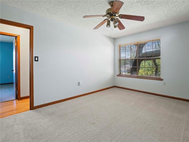 carpeted spare room with a textured ceiling and ceiling fan