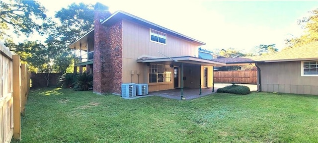 rear view of property with a patio, cooling unit, and a yard