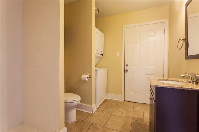 bathroom with tile patterned flooring, vanity, toilet, and stacked washing maching and dryer