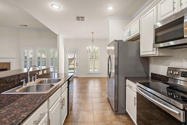 kitchen featuring appliances with stainless steel finishes, ornamental molding, sink, light tile patterned floors, and white cabinetry