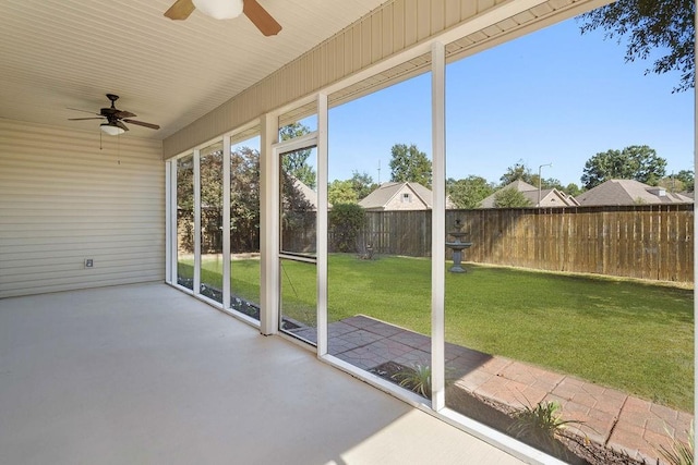 unfurnished sunroom with ceiling fan