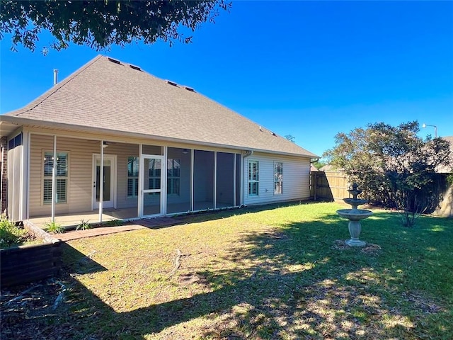 rear view of house with a lawn, a patio area, and a sunroom