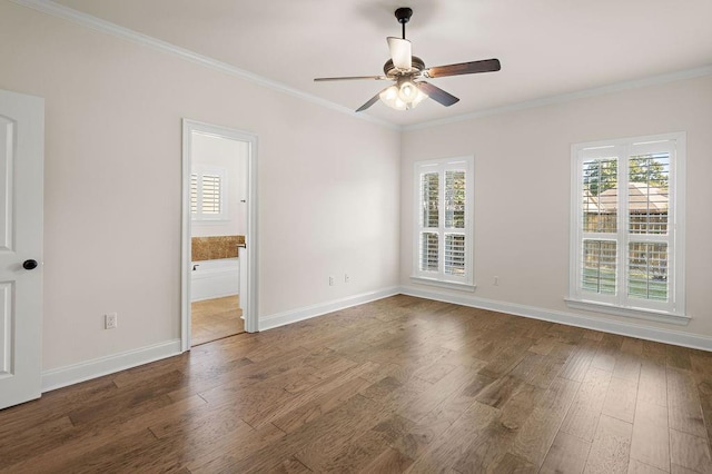 empty room featuring a wealth of natural light, dark hardwood / wood-style floors, and ornamental molding