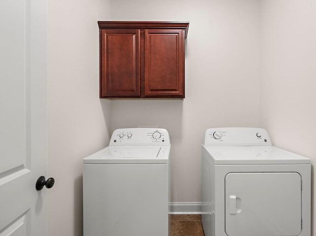 laundry room with washing machine and dryer, tile patterned flooring, and cabinets