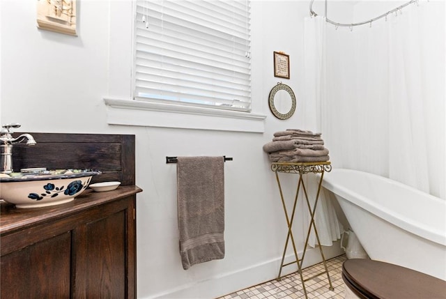 bathroom featuring tile patterned floors, toilet, and a tub