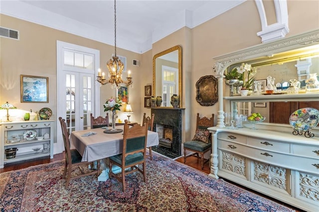 dining room featuring a premium fireplace, a notable chandelier, and dark hardwood / wood-style flooring