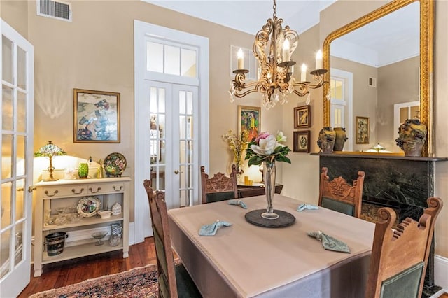 dining space with french doors, a chandelier, and dark hardwood / wood-style floors