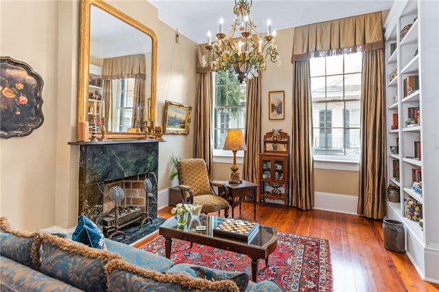 living area with wood-type flooring, a chandelier, and a premium fireplace