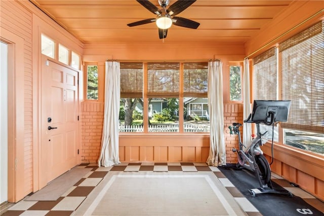 exercise room featuring brick wall and ceiling fan