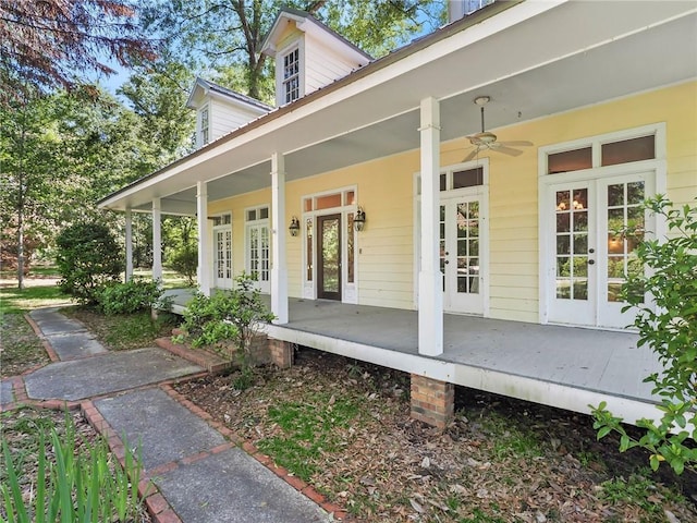 view of exterior entry featuring ceiling fan and a porch