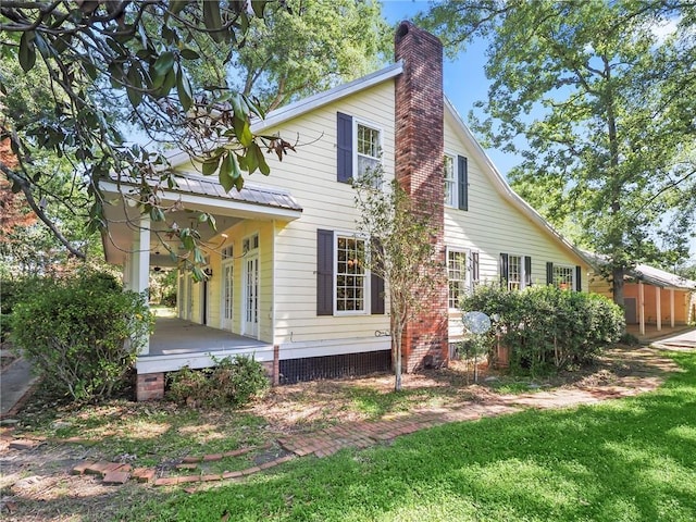 rear view of house with french doors, a porch, and a lawn