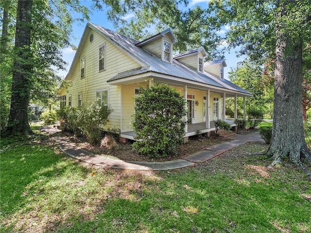 view of home's exterior featuring a lawn and covered porch