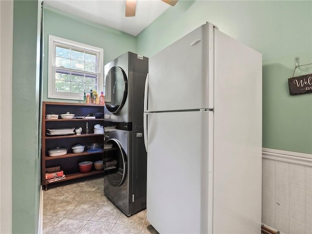 washroom with ceiling fan, light tile patterned floors, and stacked washing maching and dryer