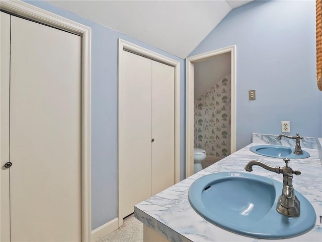 bathroom featuring vanity, vaulted ceiling, and toilet