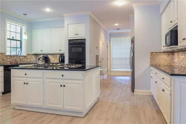 kitchen with decorative backsplash, light hardwood / wood-style flooring, black appliances, crown molding, and white cabinets