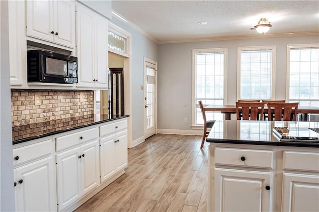 kitchen with white cabinetry, a textured ceiling, light hardwood / wood-style floors, and plenty of natural light