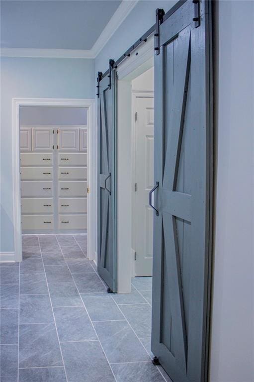 hall with crown molding, a barn door, and light tile patterned flooring