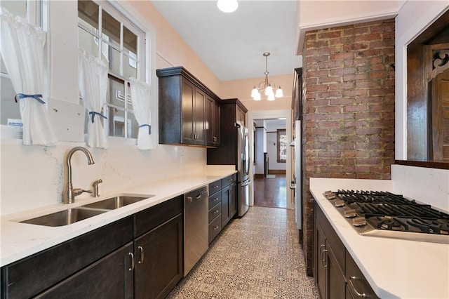 kitchen with appliances with stainless steel finishes, sink, dark brown cabinets, hanging light fixtures, and an inviting chandelier