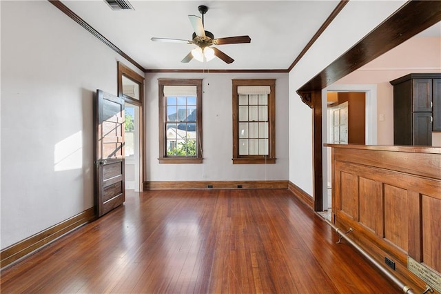 empty room featuring ceiling fan, crown molding, and dark hardwood / wood-style flooring