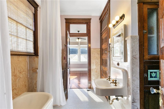 bathroom with ornamental molding, tile patterned flooring, a tub to relax in, and plenty of natural light